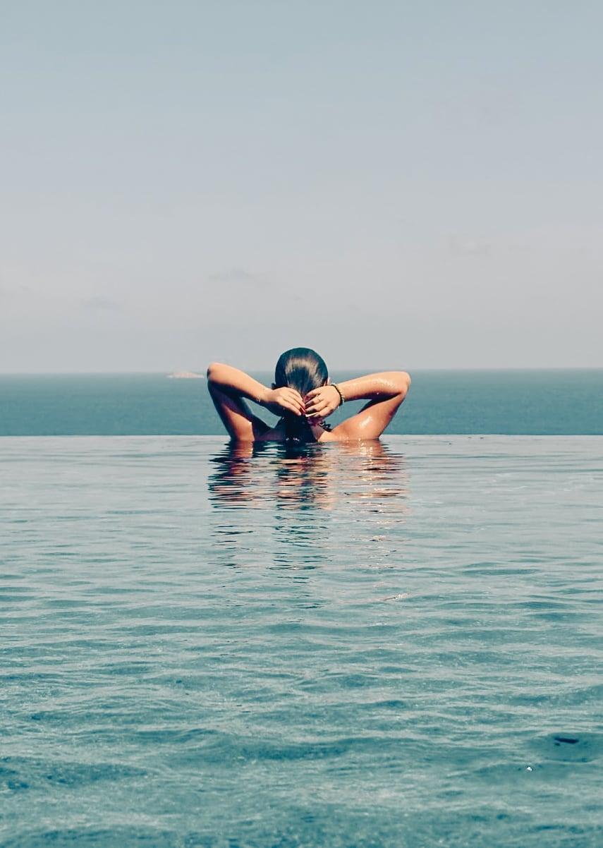 Baigneuse dans la piscine à débordement face à la baie
